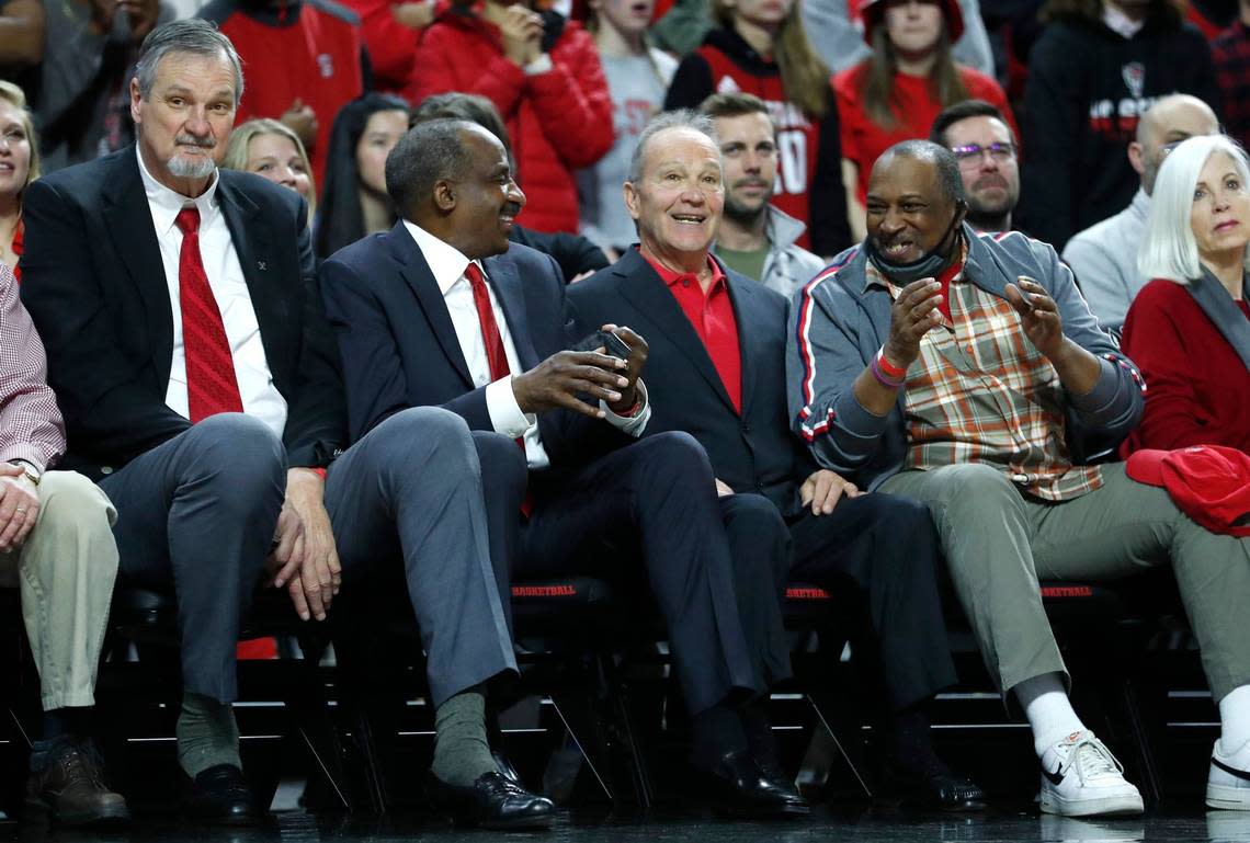 Members of the NC State’s 1974 team, from left, Tommy Burleson, David Thompson, Monte Towe and Moe Rivers, talk with each other during the first half of N.C. State’s game against UNC at PNC Arena in Raleigh, N.C., Saturday, Feb. 26, 2022.