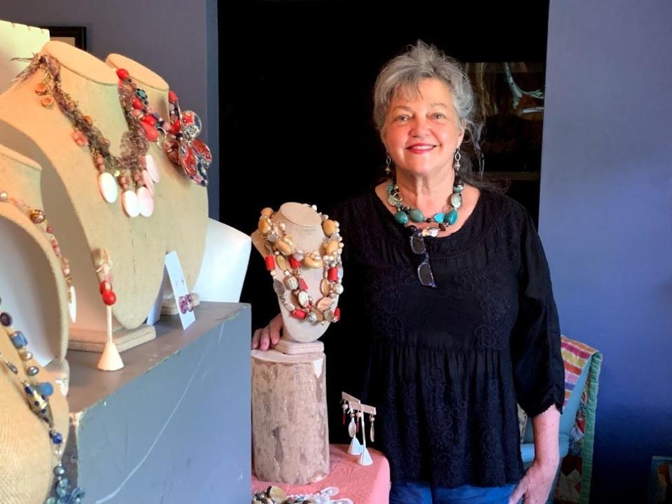 Quincie Hamby stands with jewelry she makes and sells.