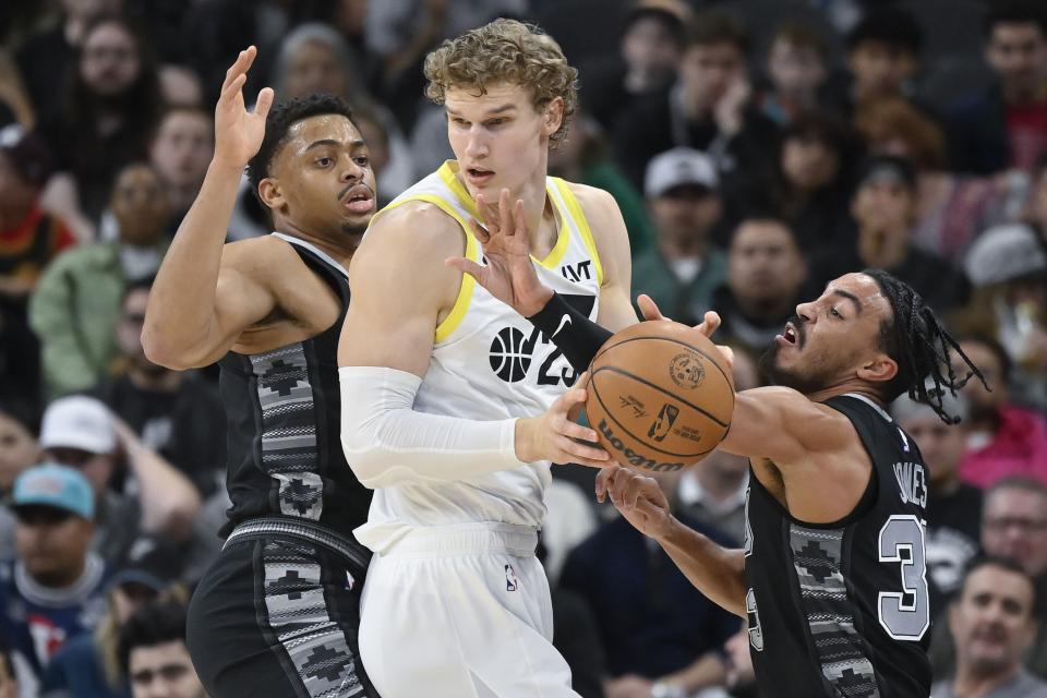 Utah Jazz’s Lauri Markkanen, center, is defended by San Antonio Spurs’ Tre Jones, right, and Keldon Johnson during the first half of an NBA basketball game Tuesday, Dec. 26, 2023, in San Antonio. | Darren Abate, Associated Press