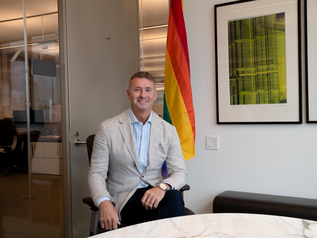 michael broadbery with a pride flag in office