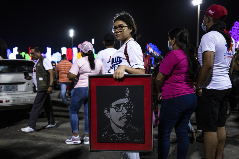 A youth carries a portrait of Nicaraguan President Daniel Ortega during commemorations for the anniversary of the triumph of the 1979 Sandinista Revolution that toppled dictator Anastasio Somoza in Managua, Nicaragua, late Sunday, July 18, 2021. (AP Photo/Miguel Andrés)