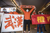 In this photo released by Xinhua News Agency, supporters of Wuhan FC then known as Wuhan Zall hold up banners with the words "Wuhan" "Sure Win" as their team returns to Wuhan railway station in Wuhan in central China's Hubei Province on April 18, 2020. The club endured quite an ordeal last year after first being stranded in Spain on a preseason tour as its home city was overrun by the virus, and then fleeing the country just before the outbreak hit Europe hard. (Xiao Yijiu/Xinhua via AP)