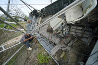 Mike Gaines, a deckhand, sits on the overturned and destroyed shrimp trawler that provides his living, in the aftermath of Hurricane Ida in Plaquemines Parish, La., Monday, Sept. 13, 2021. (AP Photo/Gerald Herbert)