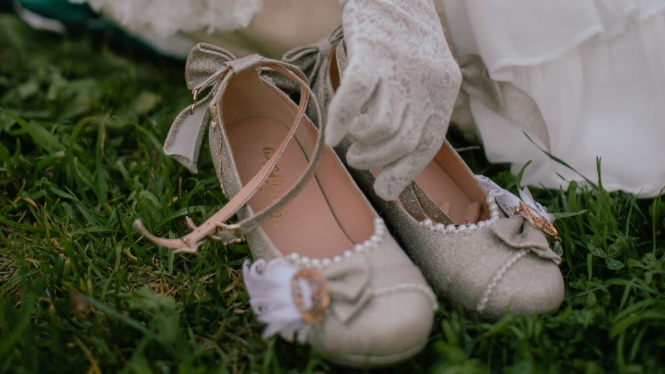 Nghi, wearing white, lace gloves, enjoys a tea party at a garden in Oakland, California, on Feb. 25, 2021. Some Lolitas use knee socks, ankle socks, or tights, together with either high heels or flat shoes with a bow. - Shelby Knowles