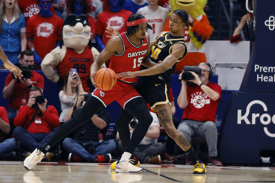 Dayton's DaRon Holmes, left, posts up against Virginia Commonwealth's Toibu Lawal, right, during the first half of an NCAA college basketball game Friday, March 8, 2024, in Dayton, Ohio. (AP Photo/Jay LaPrete)