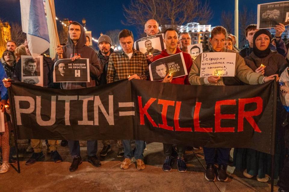 A sign calls Russian President Vladimir Putin a killer at a candlelight vigil in downtown Sacramento on Tuesday to mourn the loss of Alexei Navalny, the Russian opposition leader who died in an Arctic penal colony earlier this month. 
