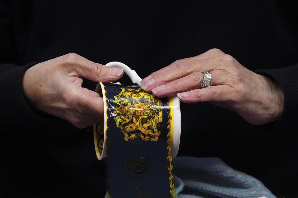 A worker sticks the paint on official chinaware at a pottery factory in Stoke-on-Trent where the official Coronation chinaware is produced on behalf of Royal Collection Trust.<span class="copyright">PA Images/AP</span>