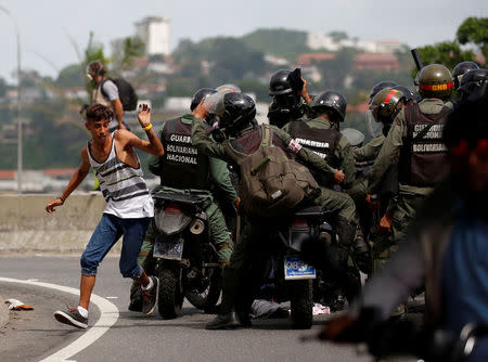 Riot security forces try to grab a man while clashing with demonstrators rallying against President Nicolas Maduro in Caracas, Venezuela. REUTERS/Carlos Garcia Rawlins