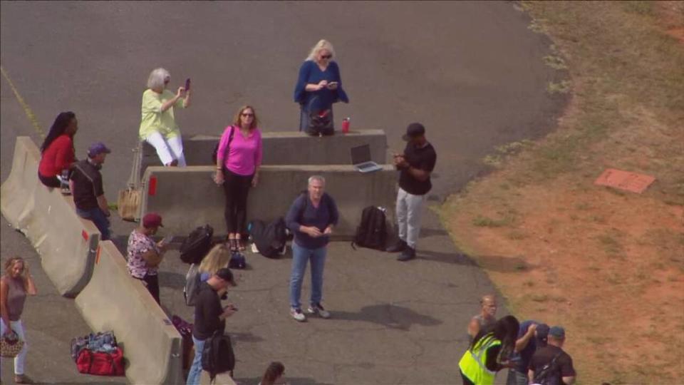 Passengers wait on the tarmac at Charlotte Douglas International Airport on Monday, June 27, 2022. A report for a possible odor in the jet cabin forced the Florida-bound flight to be stopped on the taxiway.