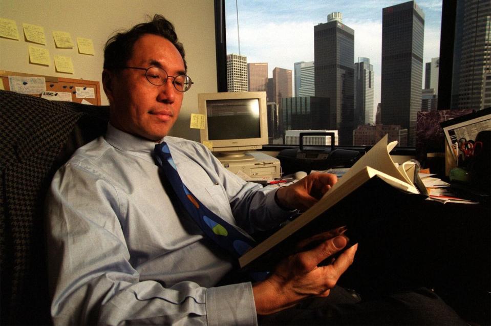 Mike Woo reading in his Los Angeles office.