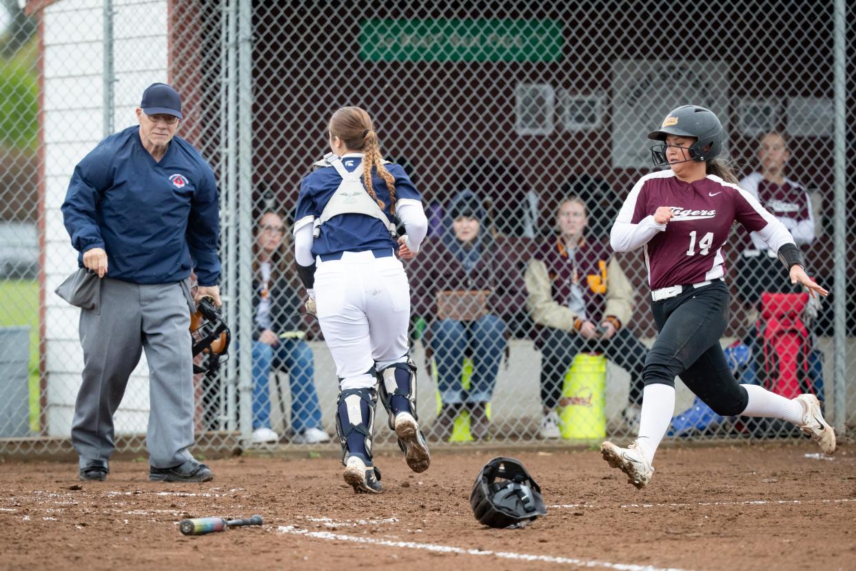 Junction City’s Lily Buendia runs safely home as the Junction City Tigers host the Marist Spartans Friday, April 26, 2024, at Junction City High School.