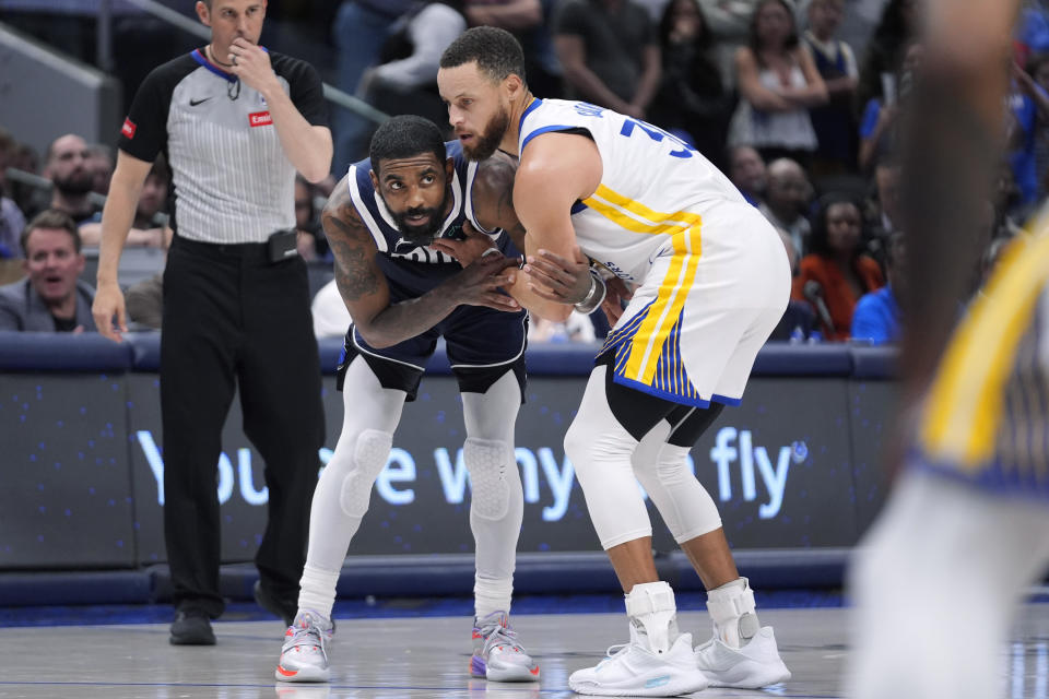 Dallas Mavericks guard Kyrie Irving, left, is guarded by Golden State Warriors guard Stephen Curry (30) during the second half of an NBA basketball game in Dallas, Friday, April 5, 2024. (AP Photo/LM Otero)