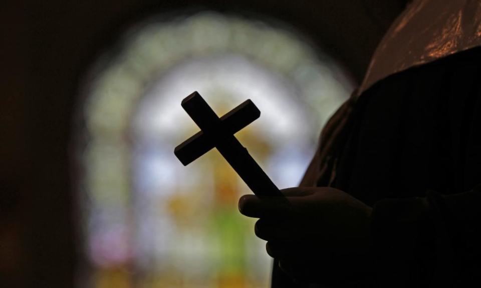 Priest holds a cross