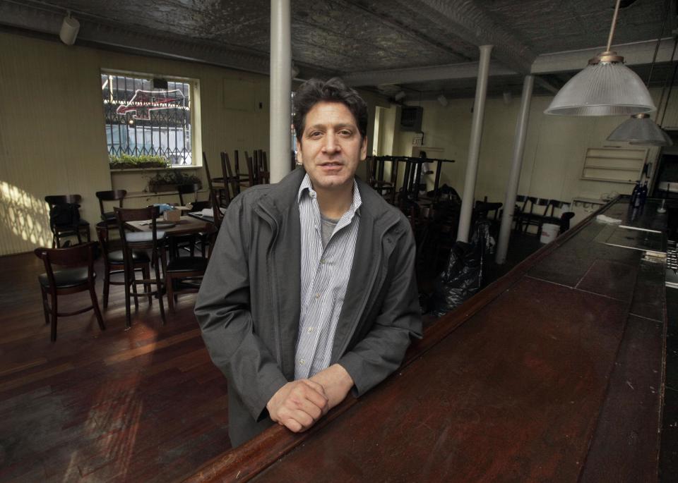 FILE - In this file photo of Dec. 4, 2012, photo, proprietor Adam Weprin, of the Bridge Cafe, in New York's South Street Seaport, poses for a photo at the restaurant's bar after his establishment was shuttered by Superstorm Sandy. Nearly four months after Superstomr Sandy hit, the historic cobblestone streets near the water's edge in lower Manhattan are eerily deserted, and among local business owners, there is a pervasive sense that their plight has been ignored by the rest of Manhattan. (AP Photo/Richard Drew, File)