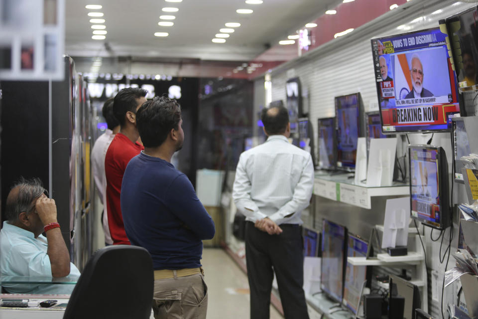 Indians watch Prime Minister Narendra Modi address the nation in a televised speech, at an electronics store in Jammu, India, Thursday, Aug. 8, 2019. Modi says a federally-ruled Indian portion of Kashmir will help end decades-old separatism incited by archrival Pakistan. Describing changes in Kashmir as historic, Modi assures Kashmiri people that the situation in the region will soon become normal. (AP Photo/Channi Anand)