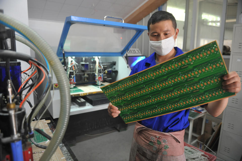 FILE - In this May 22, 2018 file photo, a staff member works in a circuit board manufacturing facility in Hangzhou in eastern China's Zhejiang province. In a report issued Monday, May 20, 2019, a business group says the number of foreign companies in China that feel compelled to hand over technology in exchange for market access has doubled since two years ago. (Chinatopix via AP, File)