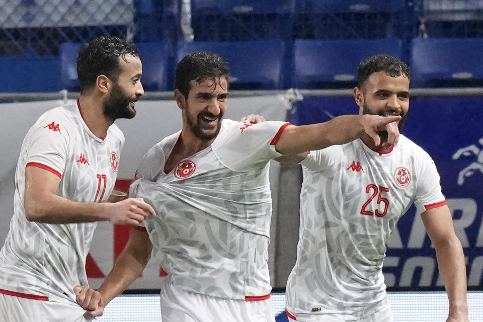 Tunisia's Mohamed Ali Ben Romdhane, center, celebrates after scoring a goal during the match between Japan and Tunisia at the Kirin Cup soccer tournament in Suita, west Japan, Tuesday, June 14, 2022. (AP Photo/Eugene Hoshiko)