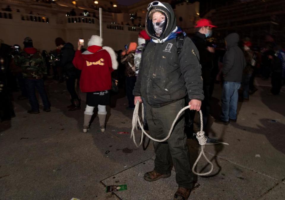 A protester carries a noose while standing outside the Capitol.