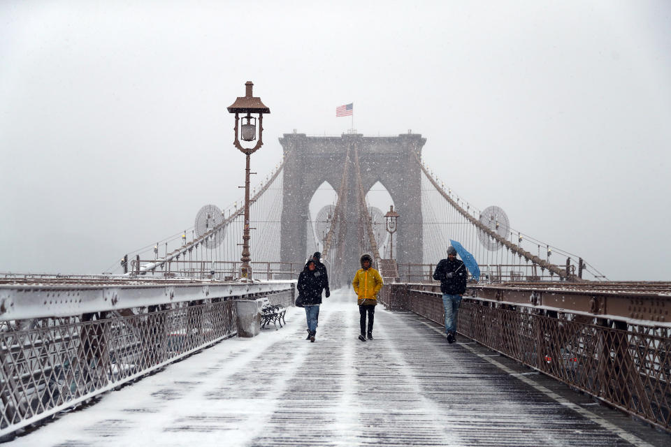 <p>Pedestrians cross the Brooklyn Bridge in New York City as a spring storm hit the Northeast with strong winds and a foot or more of snow expected in some parts of the region on Wednesday, March 21, 2018. (Photo: Gordon Donovan/Yahoo News) </p>