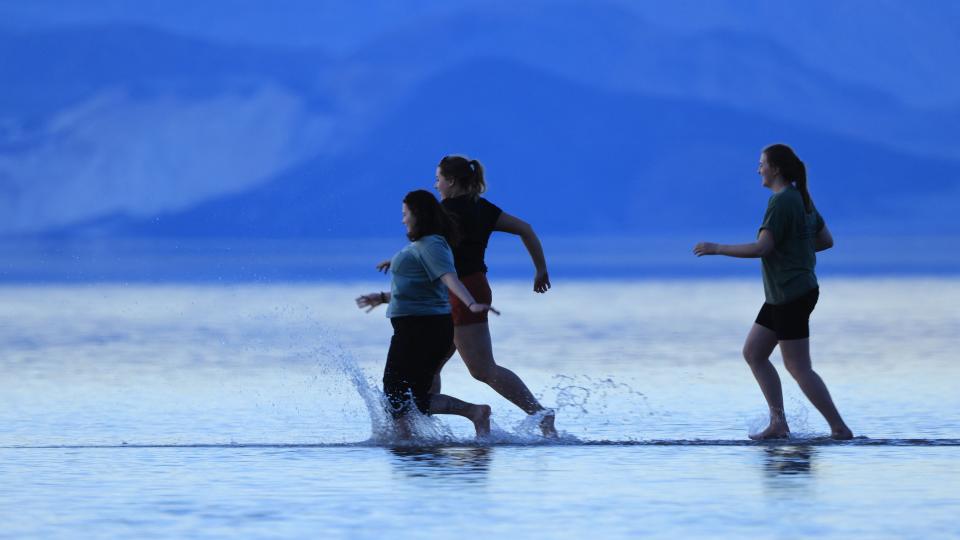 Tourists enjoy the rare opportunity to walk in water as they visit Badwater Basin