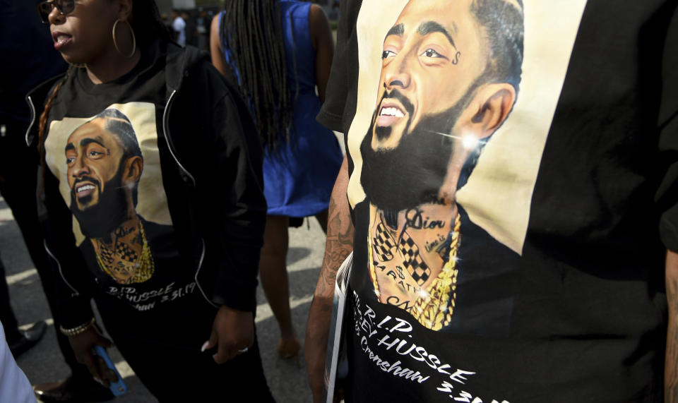 Guests wear t-shirts in tribute to Nipsey Hussle, whose given name was Ermias Asghedom, at the late rapper's Celebration of Life memorial service on Thursday, April 11, 2019, at the Staples Center in Los Angeles. (Photo by Chris Pizzello/Invision/AP)