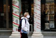 FILE PHOTO: A woman wearing a protective face mask walks in downtown Budapest
