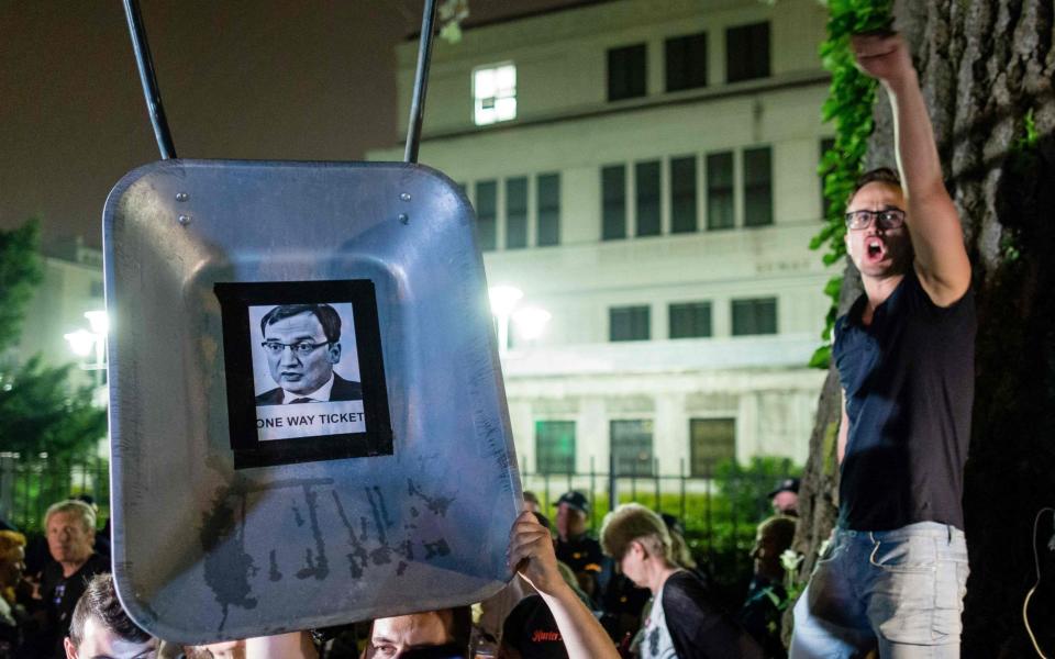 A protester shouts slogans and gestures by a picture of Polish Justice Minister Zbigniew Ziobro stuck on wheelbarrow - Credit: Wojtek Radwanski/AFP