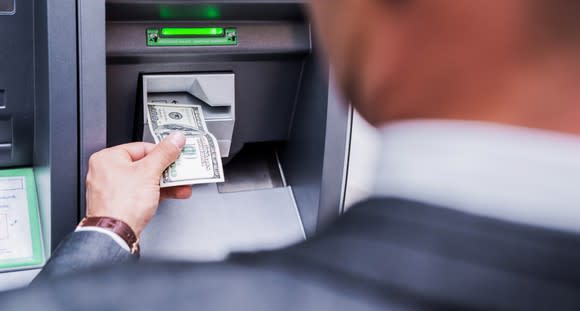 Man in suit using an ATM.