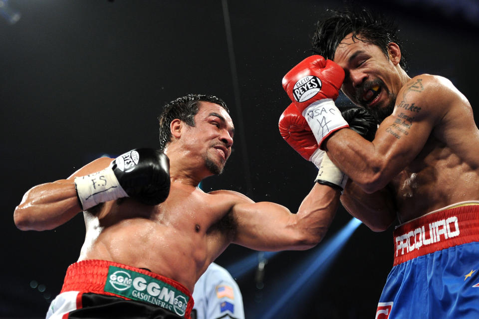 LAS VEGAS, NV - NOVEMBER 12: (L-R) Juan Manuel Marquez throws a left to the face of Manny Pacquiao during the WBO world welterweight title fight at the MGM Grand Garden Arena on November 12, 2011 in Las Vegas, Nevada. (Photo by Harry How/Getty Images)