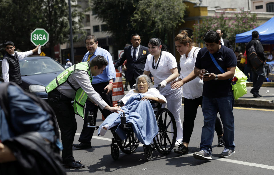 <p>A woman in a wheelchair is evacuated from a clinic as people gather along Paseo de la Reforma Avenue after an earthquake in Mexico City, Tuesday Sept. 19, 2017. A powerful earthquake jolted central Mexico on Tuesday, causing buildings to sway sickeningly in the capital on the anniversary of a 1985 quake that did major damage. (AP Photo/Marco Ugarte) </p>