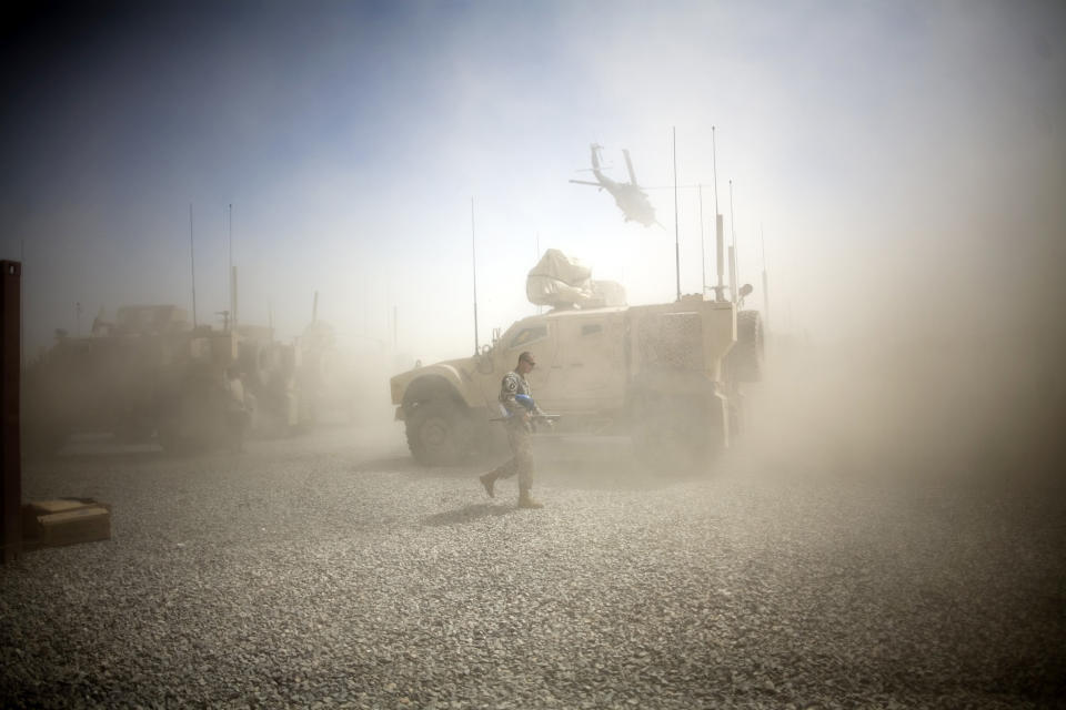 <p>A U.S. Army soldier takes cover from dust whipped up by a departing helicopter at Combat Outpost Terra Nova in Kandahar, Afghanistan, July 19, 2010. </p>
