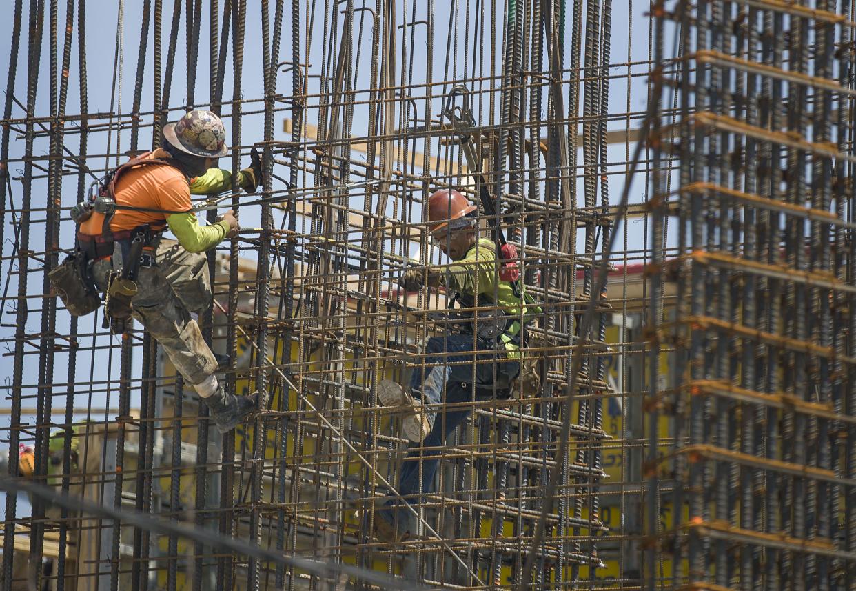 Construction workers are seen as they work with steel rebar during the construction of a building on May 17, 2019 in Miami, Florida.