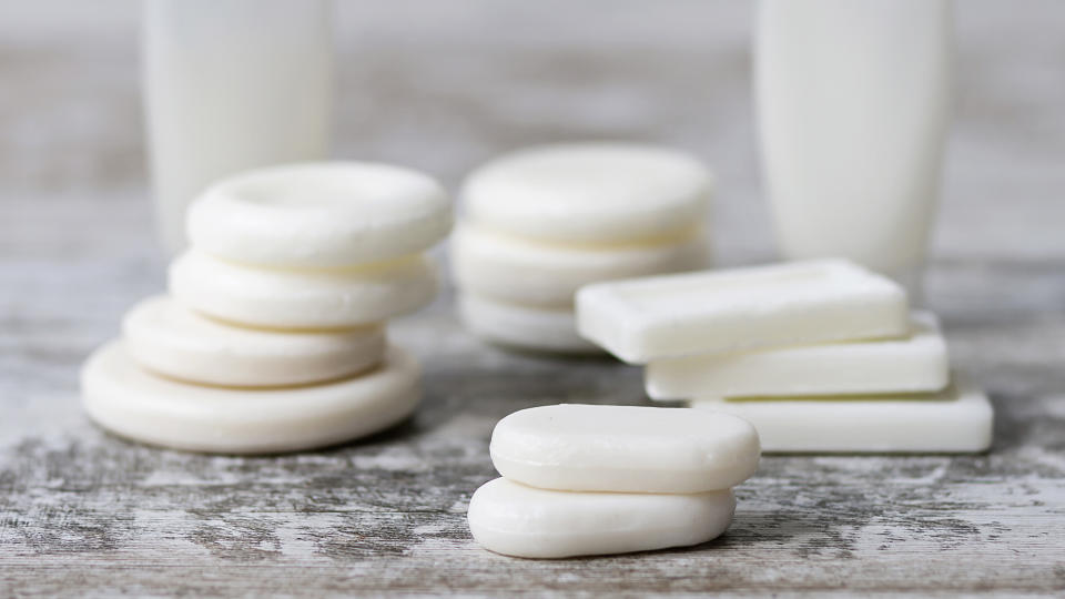 Small white soap bars stacked on a wooden tabletop to use as a moth balls alternative