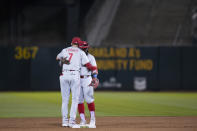 Philadelphia Phillies shortstop Trea Turner, left, and second baseman Josh Harrison hug after the team's 6-1 victory over the Oakland Athletics in a baseball game in Oakland, Calif., Friday, June 16, 2023. (AP Photo/Godofredo A. Vásquez)