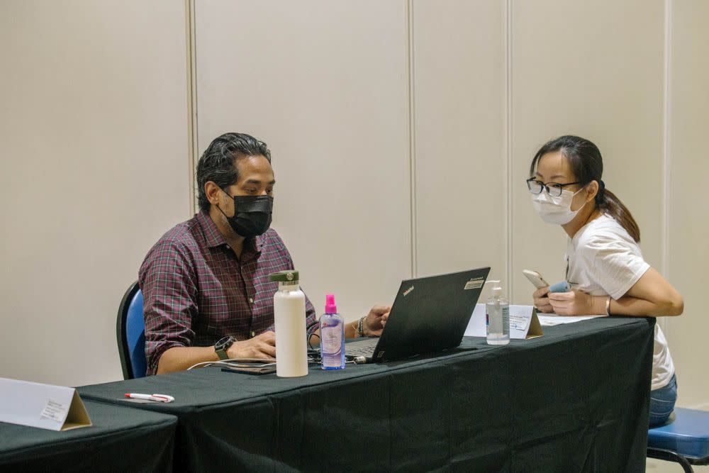 Minister of Science, Technology and Innovation Khairy Jamaluddin helps register members of the public for their AstraZeneca jab at the World Trade Centre Kuala Lumpur May 16, 2021. — Picture by Firdaus Latif