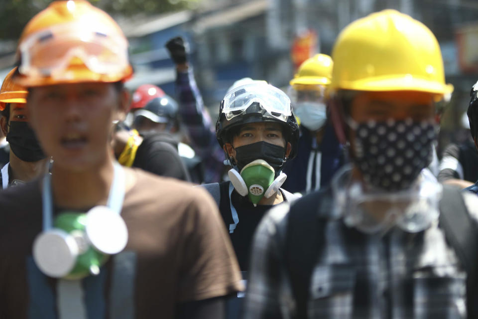 Anti-coup protesters wearing helmets and masks take positions as police gather in Yangon, Myanmar, Friday, March 5, 2021. Myanmar's military, fresh off a coup, has killed scores of unarmed protesters. It's jailed reporters, and anyone else capable of exposing the violence. The outside world has responded so far with tough words _ and little else. (AP Photo)