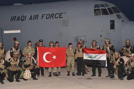 Turkish and Iraqi soldiers pose with their national flags at an airport in Sirnak province, Turkey, in this handout photo obtained by Reuters September 25, 2017. Turkish Military/Handout via REUTERS