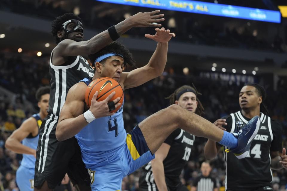 Marquette's Stevie Mitchell grabs a loose ball in front of Providence's Ticket Gaines during the first half of an NCAA college basketball game Wednesday, Feb. 28, 2024, in Milwaukee. (AP Photo/Morry Gash)