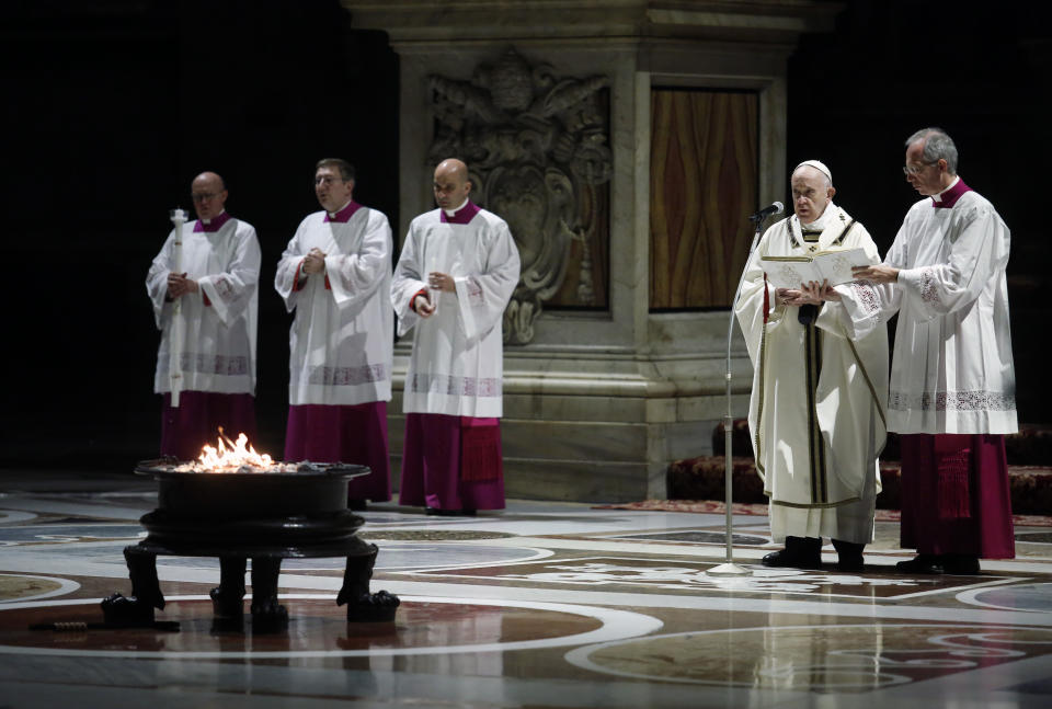 Pope Francis presides over a solemn Easter vigil ceremony in St. Peter's Basilica empty of the faithful following Italy’s ban on gatherings to contain coronavirus contagion, at the Vatican, Saturday, April 11, 2020. The new coronavirus causes mild or moderate symptoms for most people, but for some, especially older adults and people with existing health problems, it can cause more severe illness or death. (Remo Casilli/Pool Photo via AP)