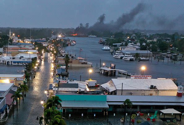 TARPON SPRINGS, FLORIDA - AUGUST 30: In an aerial view, a fire is seen as flood waters inundate the downtown area after Hurricane Idalia passed offshore on August 30, 2023 in Tarpon Springs, Florida. Hurricane Idalia is hitting the Big Bend area of Florida. (Photo by Joe Raedle/Getty Images)