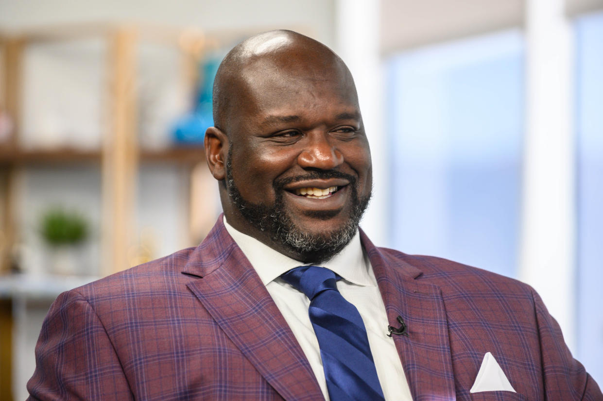 Shaquille O'Neal in a suit being interviewed.