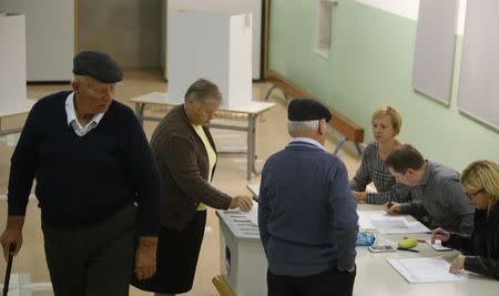 People cast their votes at a polling station during the presidential election in Vipavski Kriz, Slovenia October 22, 2017. REUTERS/Srdjan Zivulovic