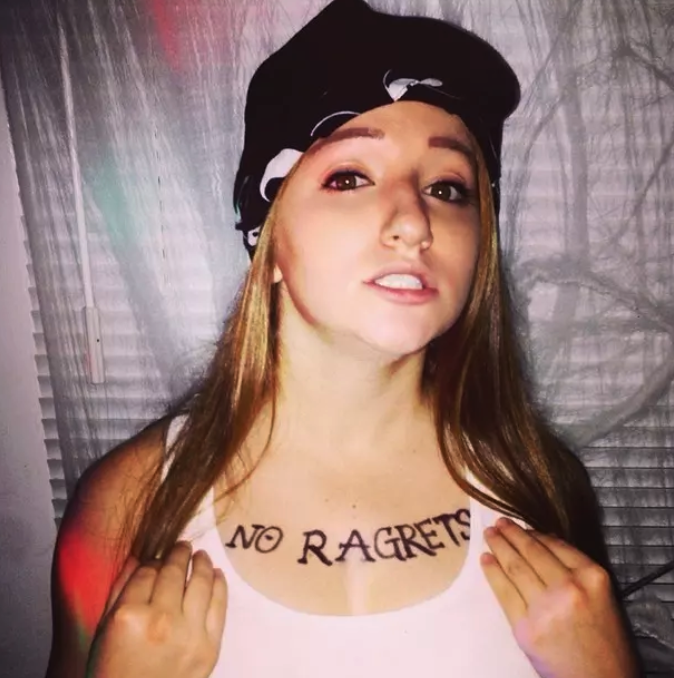 girl with the words "No Ragrets" drawn on her chest