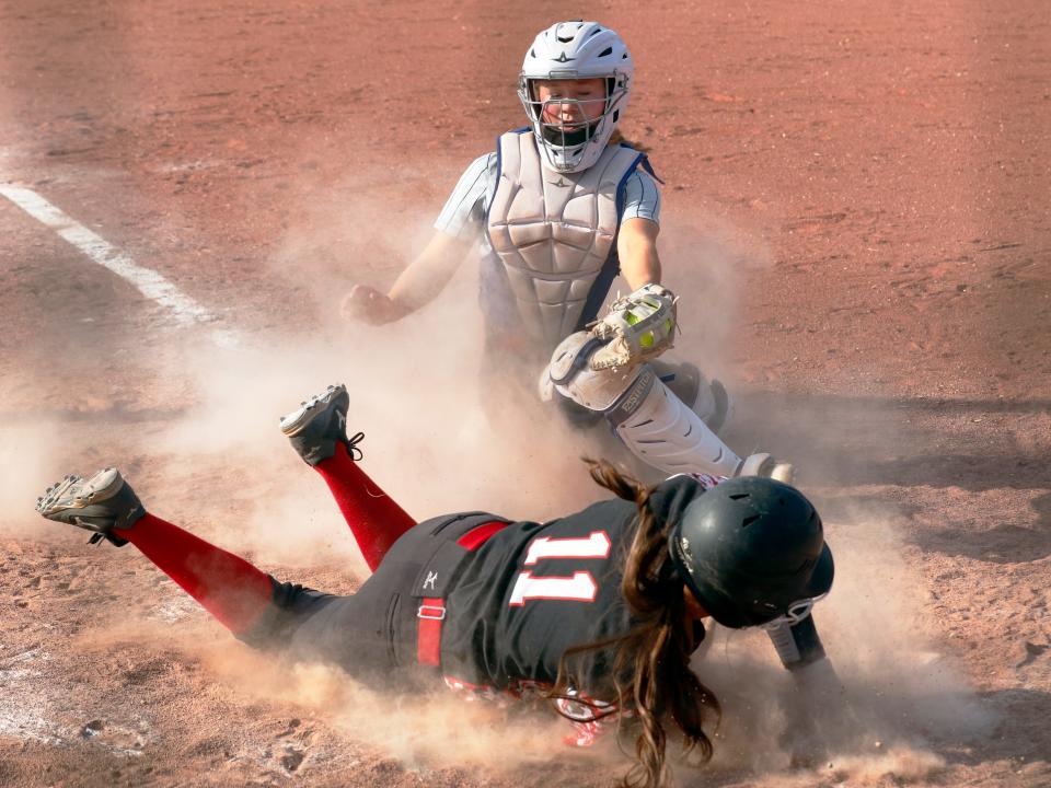 Blair Clawson lays the tag on a sliding Jazlene Brown at home plate during Morgan's 15-5 win against visiting Coshocton on Monday in McConnelsville.