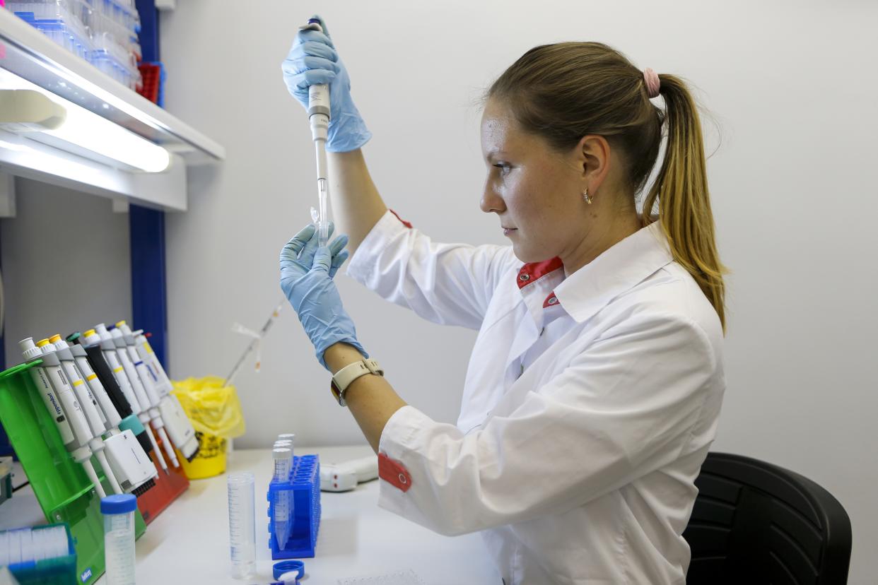 In this handout photo taken on Thursday, Aug. 6, 2020, and provided by Russian Direct Investment Fund, an employee works with a coronavirus vaccine at the Nikolai Gamaleya National Center of Epidemiology and Microbiology in Moscow, Russia. Russia on Tuesday, Aug. 11 became the first country to approve a coronavirus vaccine for use in tens of thousands of its citizens despite international skepticism about injections that have not completed clinical trials and were studied in only dozens of people for less than two months. (Alexander Zemlianichenko Jr/ Russian Direct Investment Fund via AP)