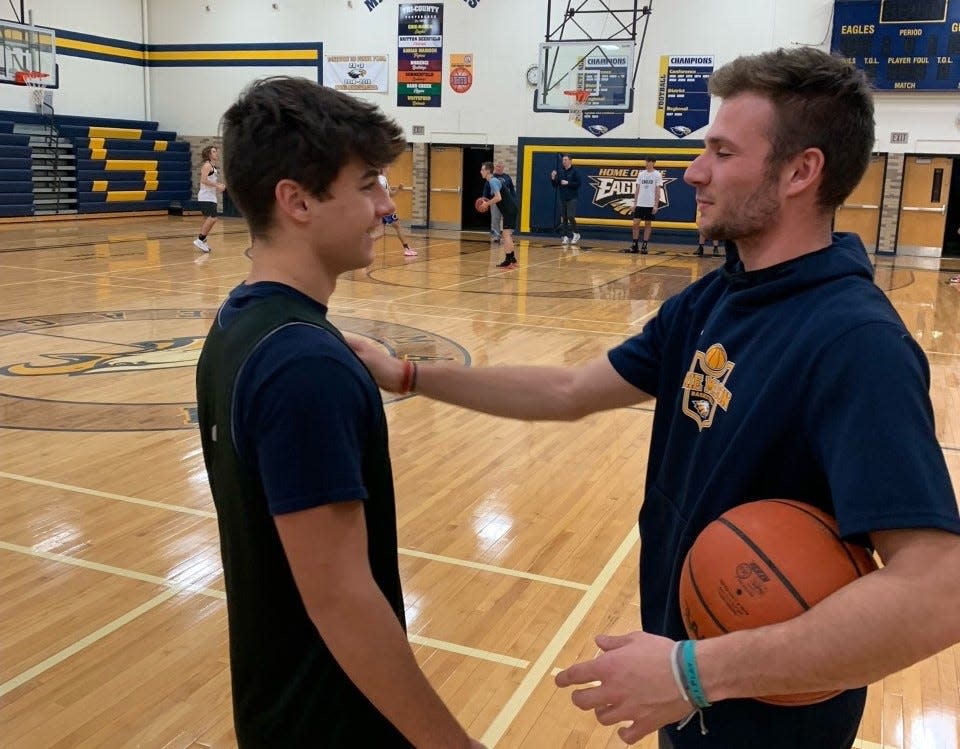 Joey Liedel (right) gives some coaching advice to Alex Langenderfer during an Erie Mason boys basketball practice Monday. Liedel, who is recovering from double-hip surgery, is helping out with Mason's team this season.