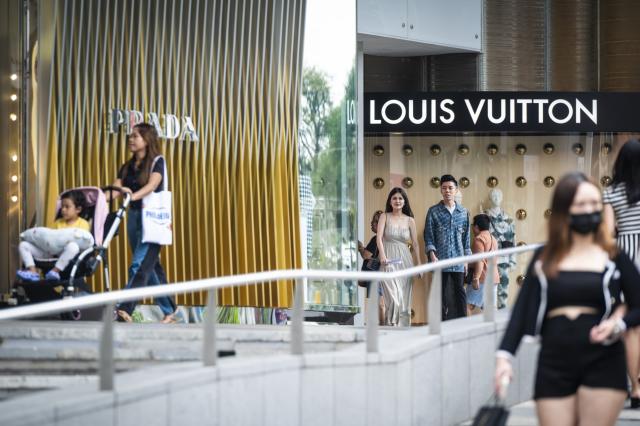 Pedestrians walk by luxury goods shops at Orchard Road. Photographer: Edwin Koo/Bloomberg