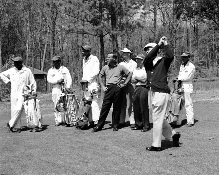 AUGUSTA, GA – APRIL 1960: Arnold Palmer (C) smokes while he waits alongside the caddies for Ben Hogan (R) to play a shot during a practice at the 1960 Masters Tournament at Augusta National Golf Club on April 7-10, 1960 in Augusta, Georgia. (Photo by Augusta National/Getty Images)