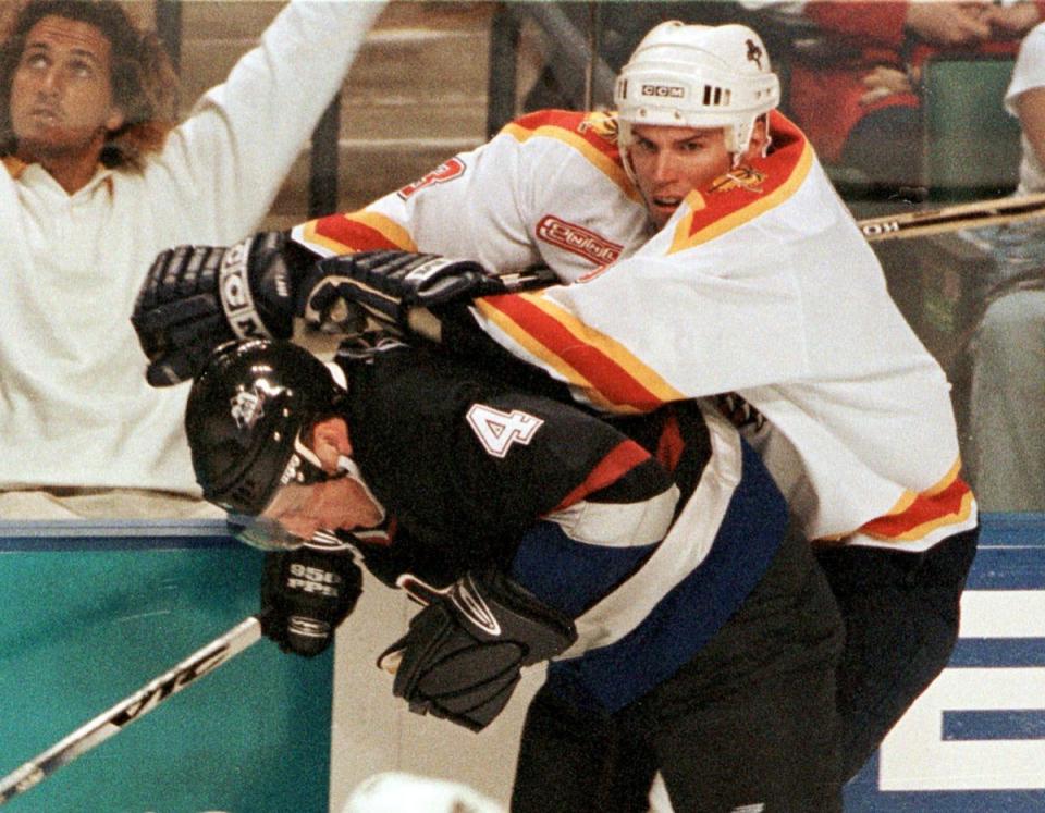 Florida's Paul Laus, right, checks Vancouver's Greg Hawgood (4). (AP Photo)