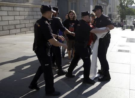 Spanish riot police try to take away a banner from pro-independence supporters during a protest near Spanish parliament in Madrid September 30, 2014. REUTERS/Andrea Comas